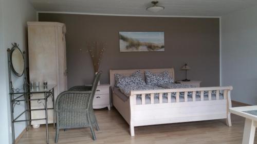 ein Schlafzimmer mit einem Bett, einem Tisch und einem Stuhl in der Unterkunft Ferienwohnung Am Sultmer mit Terrasse und Garten in Northeim