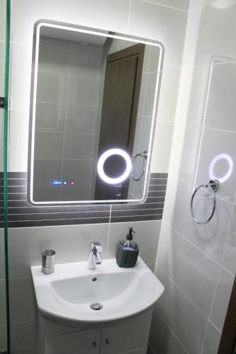 a bathroom with a white sink and a mirror at Super Central Luxury Apartments in Burgas