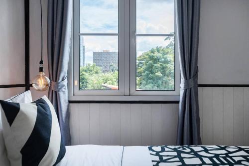 a bedroom with a window and a bed with a pillow at MIQ Asoke202 Pool Villa - Asoke BTS 16 Pax in Bangkok