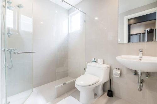 La salle de bains est pourvue de toilettes, d'un lavabo et d'une douche. dans l'établissement MIQ Asoke202 Pool Villa - Asoke BTS 16 Pax, à Bangkok