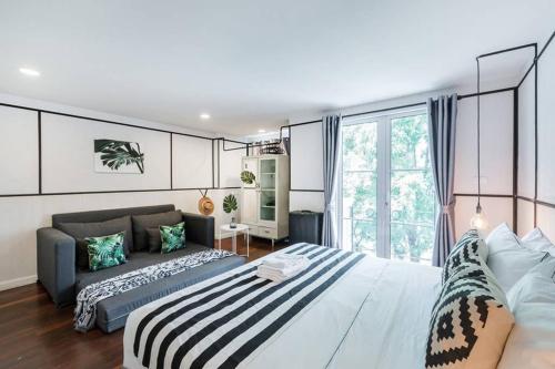 ein Schlafzimmer mit einem großen Bett und einer Couch in der Unterkunft MIQ Asoke202 Pool Villa - Asoke BTS 16 Pax in Bangkok