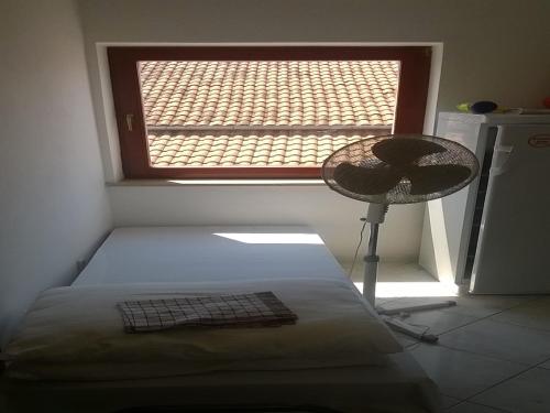 a bedroom with a bed and a window with a hat at Bernie Apartments in Poreč