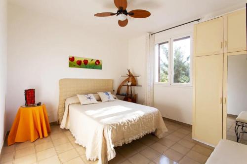 una camera da letto con un letto e un ventilatore a soffitto di Villetta dei Tramonti a Trappeto