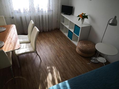 um pequeno quarto com uma mesa, cadeiras e uma secretária em Apartmán 577 em Cesky Krumlov