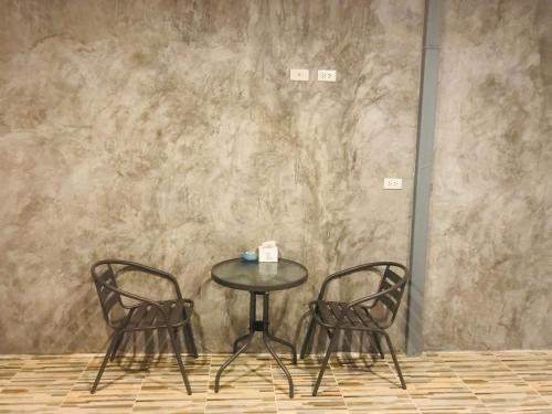 a table and two chairs in front of a wall at Koh Yao Candy House in Ko Yao Yai