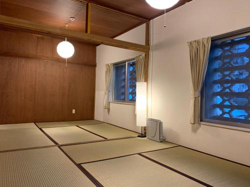 ein leeres Zimmer mit einem Zimmer mit Fenster in der Unterkunft 宿＆喫茶 アガリメージョー in Uruma