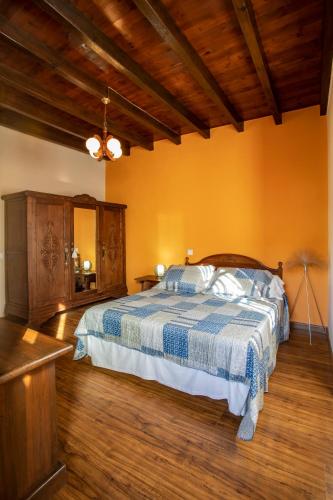 a bedroom with a bed with a blue and white blanket at Casa Güela Megustarural in Llanes