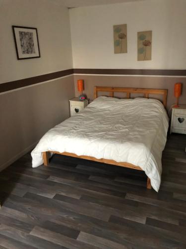 ジョンザックにあるLa Mouillèreのベッドルーム1室(白いシーツとウッドフロアのベッド1台付)