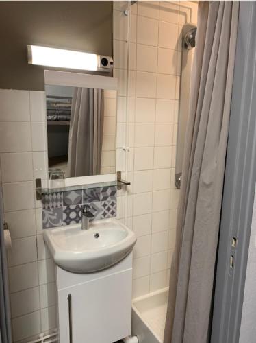 a small bathroom with a sink and a shower at Centre de vacances CAPLANDES in Capbreton