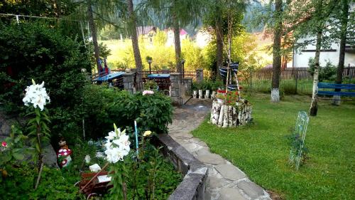 a garden with white flowers and a fence at pensiunea Gabriela in Durau