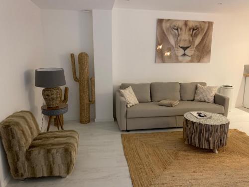 a living room with a couch and a lion painting at Victoria's House in Lille