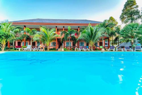 高蘭的住宿－Peaceful Resort , Long Beach - Koh Lanta，一座带游泳池的度假村,位于一座建筑前