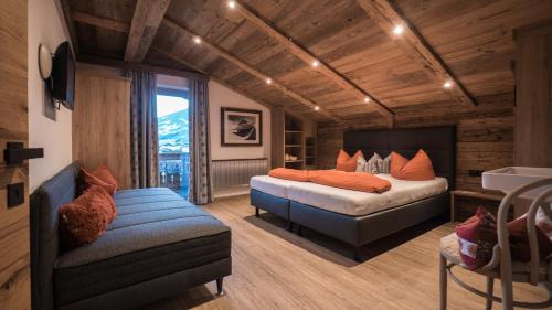 a bedroom with a bed and a couch and a chair at Apart Tyrol in Uderns