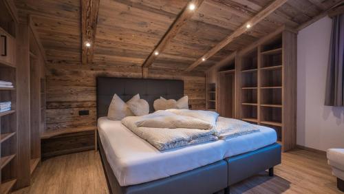 a bedroom with a large bed with wooden walls at Apart Tyrol in Uderns