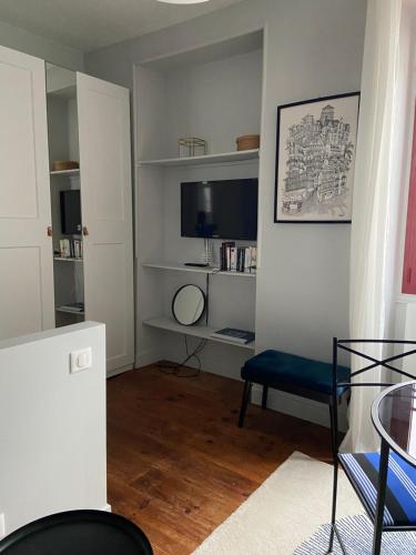 a living room with a blue chair and a television at Magnifique studio plein centre à 50m de la plage in Saint-Jean-de-Luz