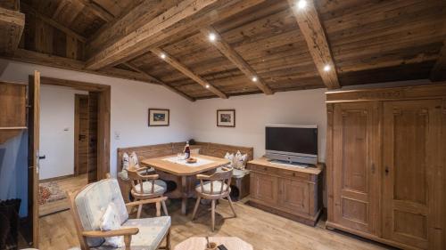 ウダーンスにあるApart Tyrolのテーブル、テレビ、椅子が備わる客室です。