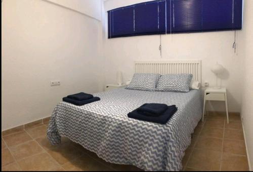 ein Schlafzimmer mit einem Bett mit blauen Handtüchern darauf in der Unterkunft Acogedor apartamento junto al mar in Las Negras