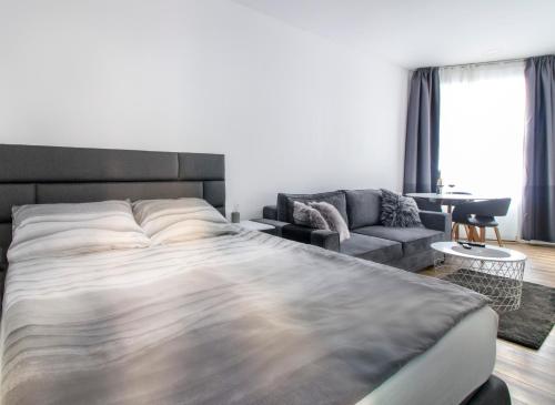 um quarto com uma cama grande e um sofá em Main Square Modern Apartments em Zagreb