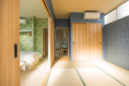 a room with a bed and a door to a bedroom at guest house Sora in Osaka