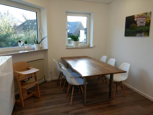 una sala da pranzo con tavolo e sedie in legno di Strietpartment - 2 Schlafzimmer, viel Raum und Ruhe a Aschaffenburg