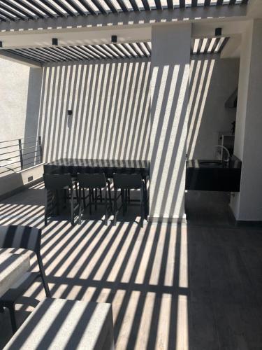 a patio with a table and chairs in the sunlight at Departamento Nuevo Plaza Ñuñoa in Santiago