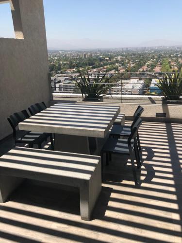 a table and chairs on a balcony with a view at Departamento Nuevo Plaza Ñuñoa in Santiago