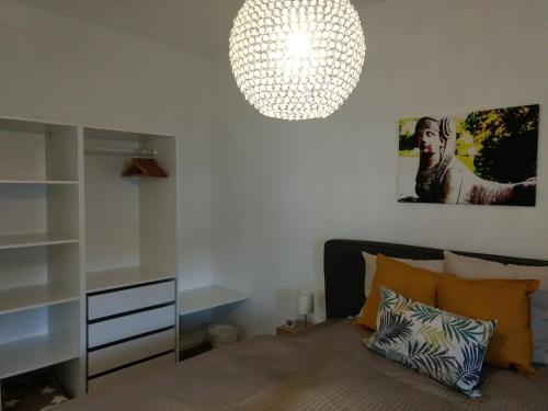 a bedroom with a bed and a chandelier at Strietpartment - 2 Schlafzimmer, viel Raum und Ruhe in Aschaffenburg