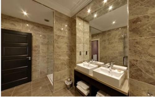 a bathroom with two sinks and a large mirror at Dumfries Arms Hotel in Cumnock