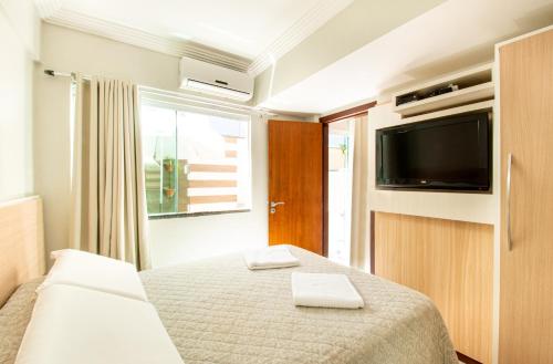 een hotelkamer met een bed en een televisie bij Pousada Cristalmar in Bombinhas