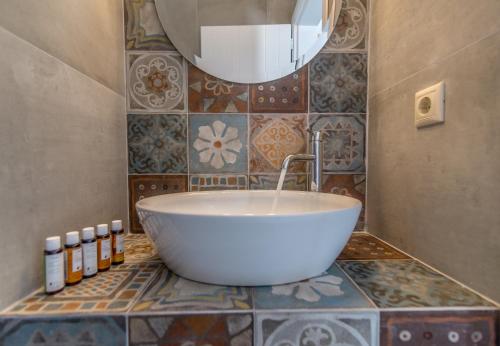a bathroom with a large white tub on a tiled floor at Manolis And Filio Home -By The Sea in Pachaina
