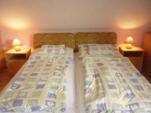2 camas en un dormitorio con 2 lámparas en las mesas en Barbara Apartmanház, en Kehidakustány
