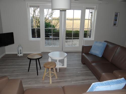 a living room with a couch and a table at strandhuis De Bakkeete A in Kamperland