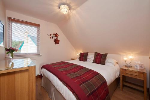 a bedroom with a large bed in a attic at The Mews Apartment at Daviot Lodge in Inverness