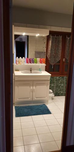La salle de bains est pourvue d'un lavabo blanc et d'un miroir. dans l'établissement BELEM, à Romorantin-Lanthenay