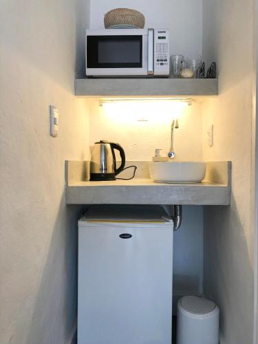 a small kitchen with a microwave and a sink at m a r ė a in José Ignacio