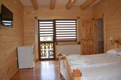 a bedroom with a bed and a refrigerator and a window at VIOLETTA in Slavske