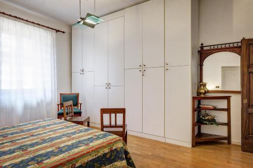 a bedroom with white cabinets and a bed and a mirror at La Rocca in Sinalunga