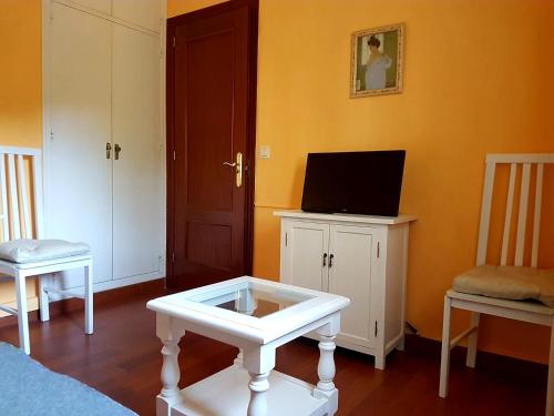 um quarto com uma televisão e uma mesa com uma televisão em Apartamento en Duplex em Jerez de la Frontera
