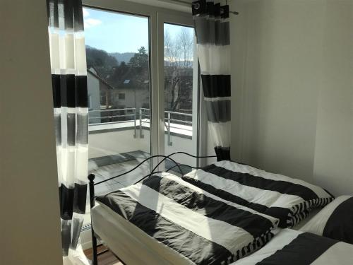 1 dormitorio con 1 cama y ventana con balcón en Attika Ferienwohnung in Freiburg -Gundelfingen mit großer Dachterrasse, en Gundelfingen