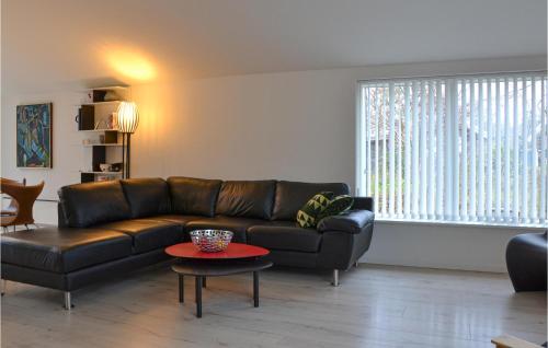 a living room with a leather couch and a table at Amazing Home In Græsted With Kitchen in Græsted