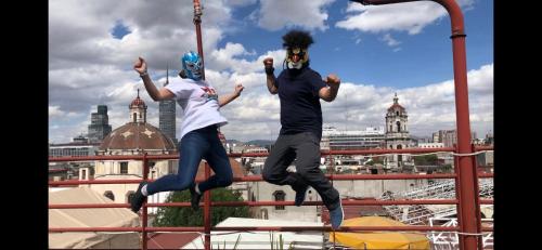 duas pessoas a saltar no ar num telhado em Casa Eufemia Hostel type em Cidade do México