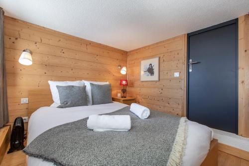 a bedroom with two beds and a blue door at Val Thorens - Cosy Duplex avec Vue Silveralp 218 in Val Thorens