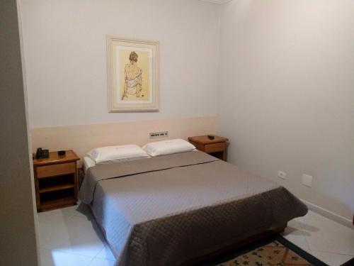 a small bedroom with a bed and two night stands at Filadelfia Hotel in Sao Paulo