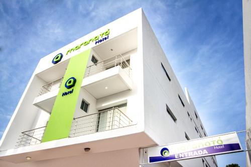 a white building with a green sign on it at Hotel Maranata Valledupar in Valledupar