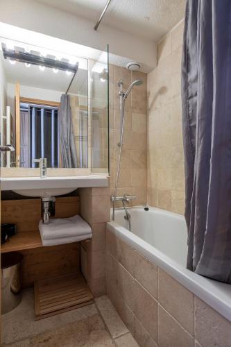 a bathroom with a sink and a tub and a shower at Val Thorens - Cosy Duplex avec Vue Silveralp 218 in Val Thorens