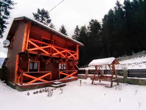 a cabin with snow on the ground in front of it at House Beskyd in Skole