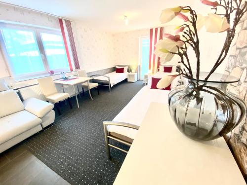 a room with a couch and a vase with flowers on a table at Apartment in Hügelsheim