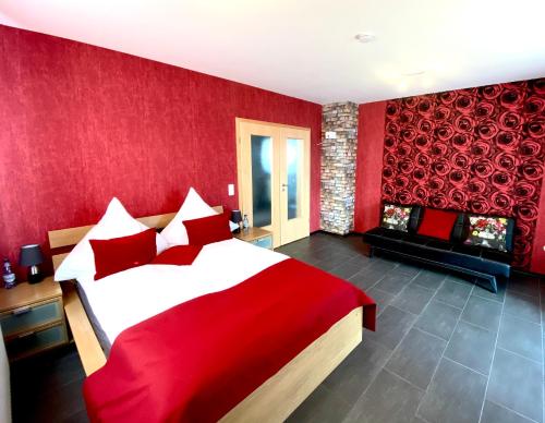 a red bedroom with a large bed and a fireplace at Apartment in Hügelsheim