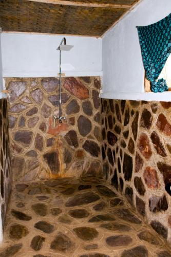 a corner of a room with a stone wall at Karungi Camp in Rubuguli