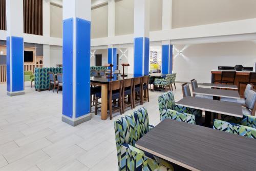 uma sala de jantar com mesas e cadeiras de madeira em Holiday Inn Express Hotel & Suites Montgomery Boyd-Cooper Parkway, an IHG Hotel em Montgomery